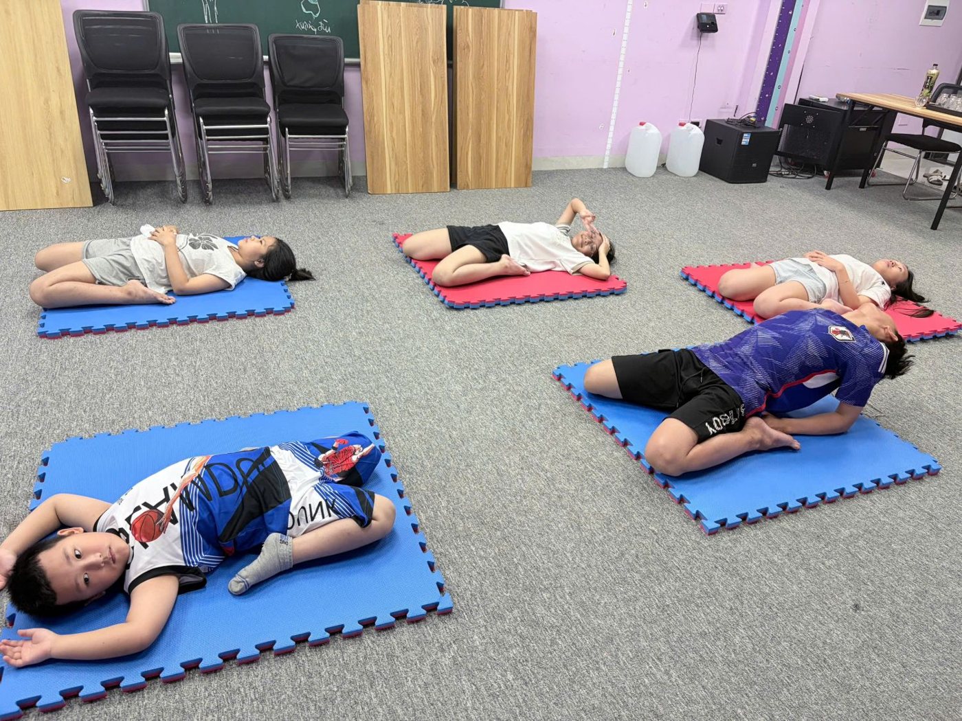 Các bạn nhỏ nằm thả lỏng trên thảm sau buổi tập